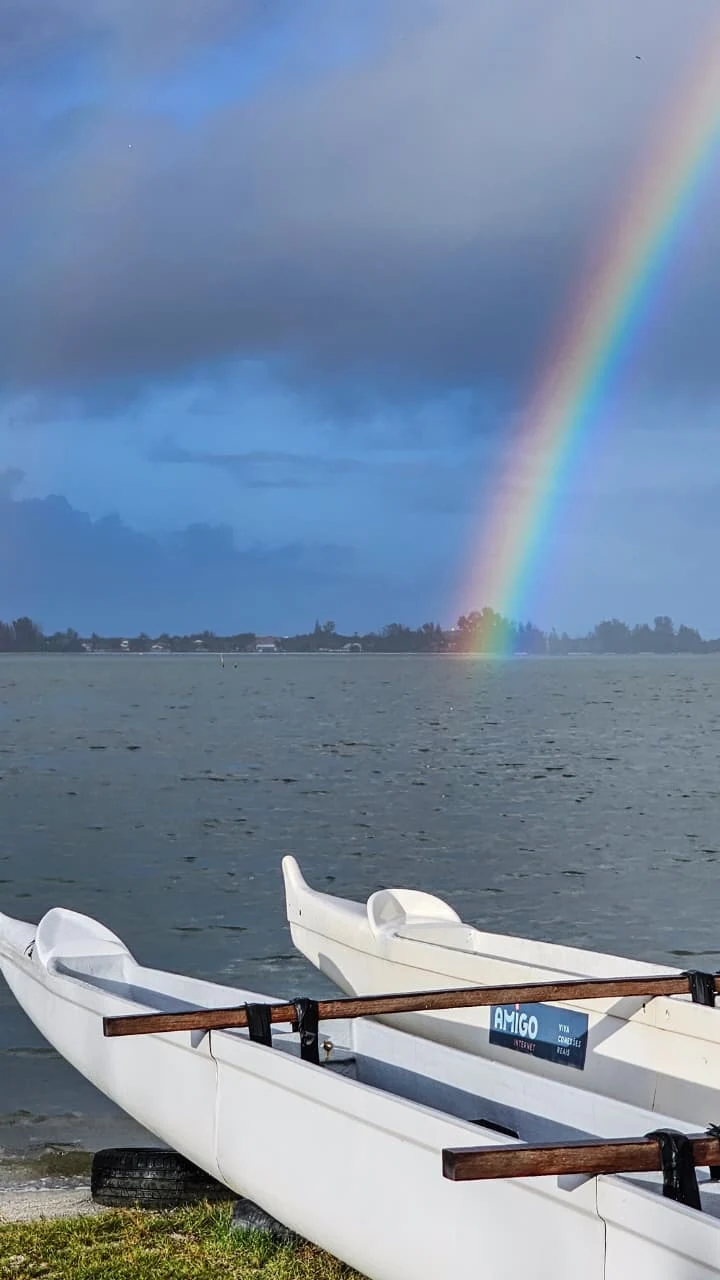 Arco-íris sobre a Laguna de Araruama, com canoas havaianas na margem